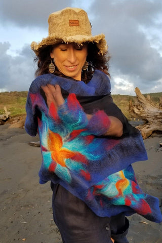 Handmade luxury wrap on a beach with a cloudy sky.
