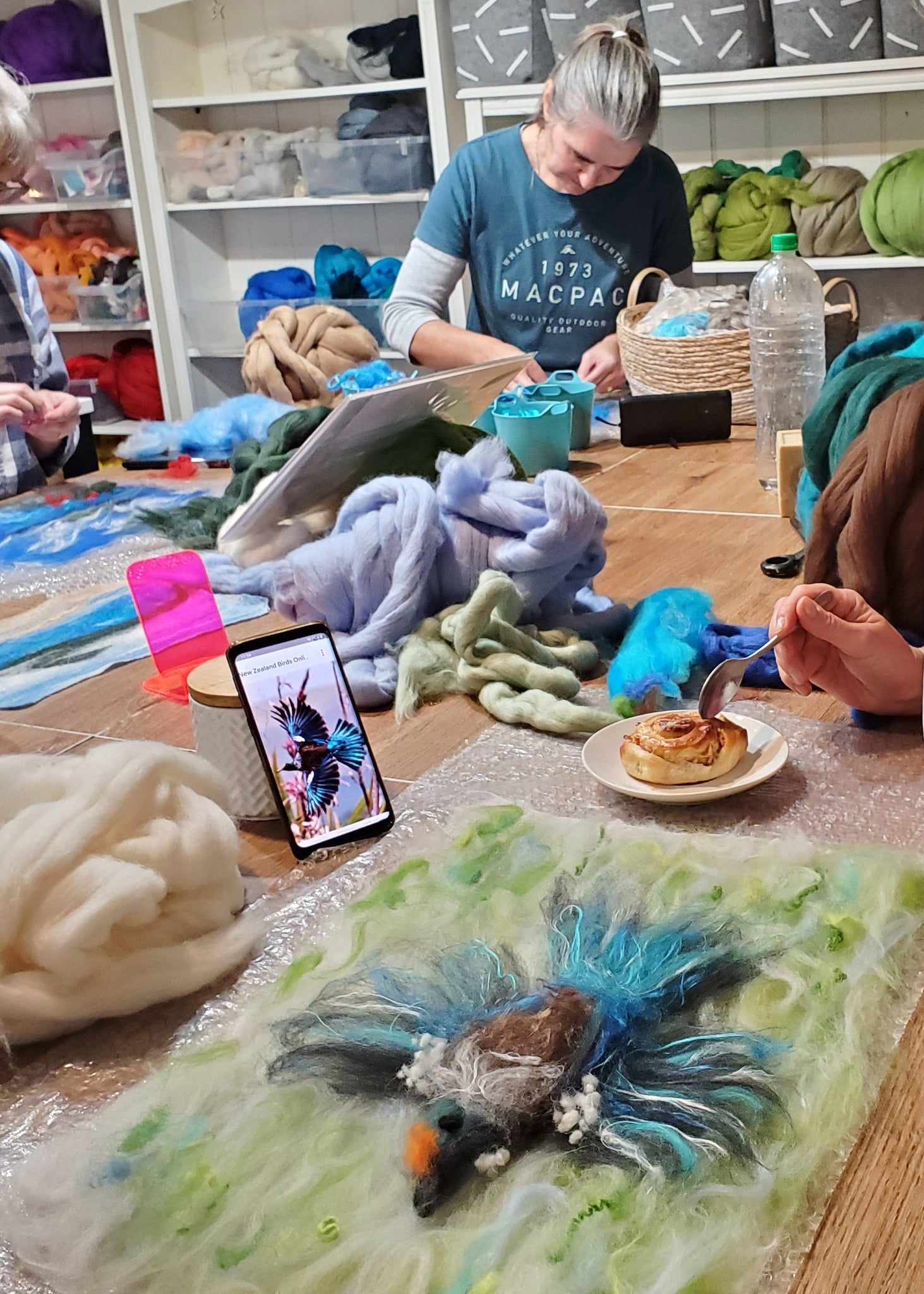 Person holding a mug with small decorative items on a table