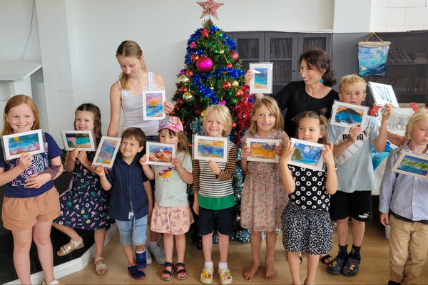 Children holding their wool painting artworks.