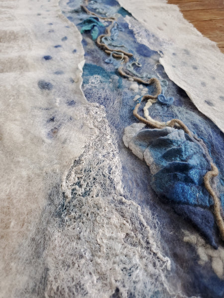 Textured fabric with blue and gray patterns on a wooden surface