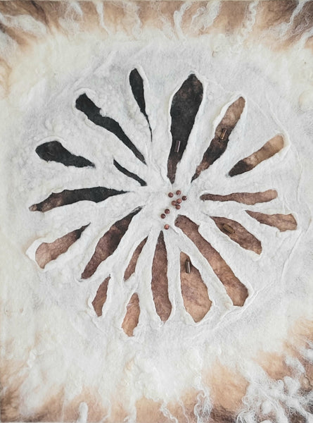 Tie-dye pattern with a starburst design in black, brown, and beige on fabric.