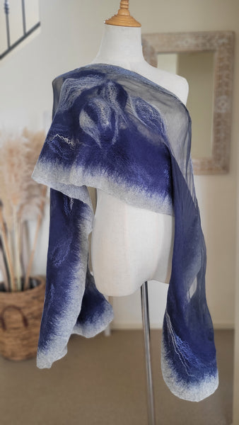 Mannequin wearing a blue and grey wool and silk scarf with a blurred  background