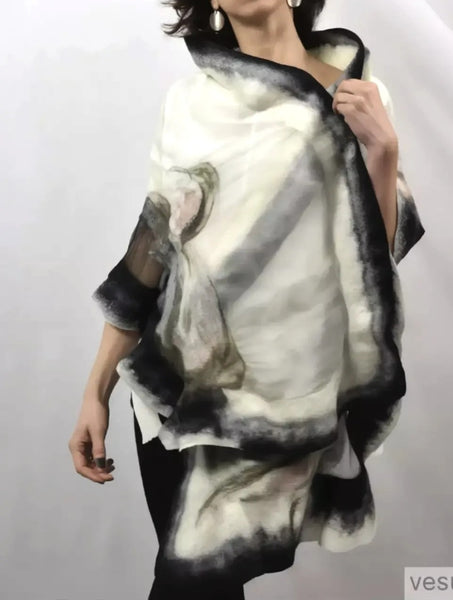 A woman wearing a white and black patterned shawl stands against a plain white background, with a neutral expression.