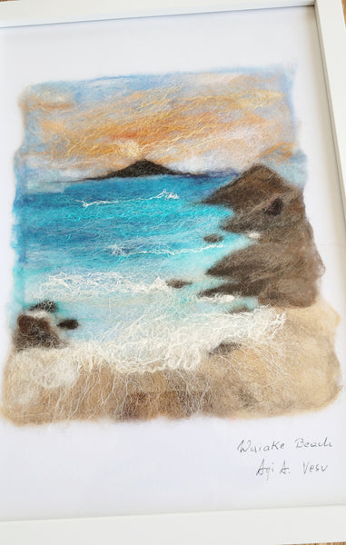 Felted artwork of a coastal scene with rocks and water.