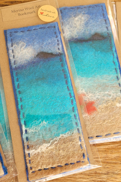 Packaged wool bookmark art with blue and beige colour swatches on a wooden surface