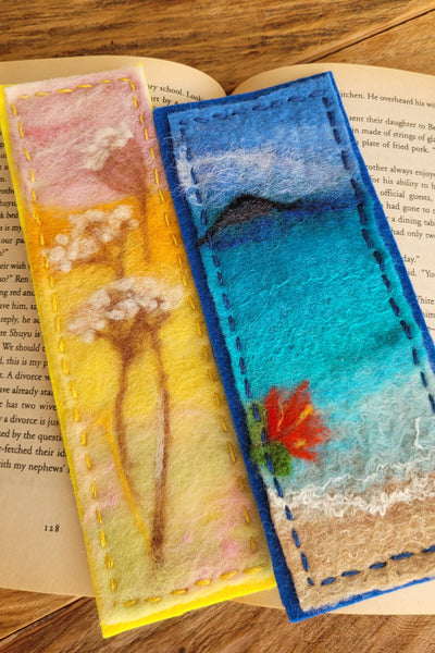 Two colorful felt bookmarks on a book with a wooden surface background
