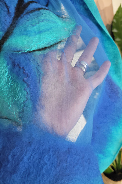 Hand with a ring on a blue textured surface