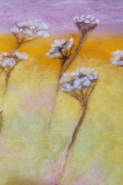 Close-up of a textured surface with yellow, pink, and purple colors and small white flowers.