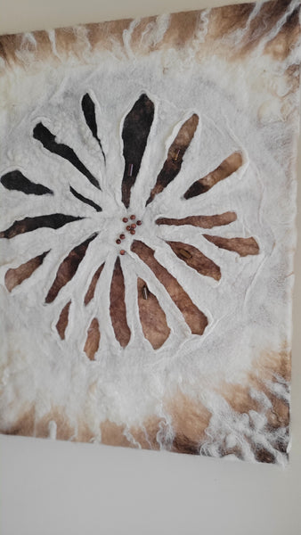 Decorative tile with a sunburst pattern on a textured surface