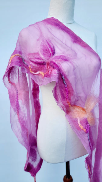 Pink scarf with floral patterns on a mannequin against a light blue background