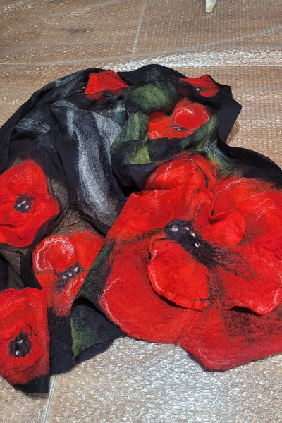 Red and black felted flowers on a textured surface
