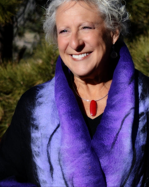 Woman wearing a purple scarf with a blurred natural background